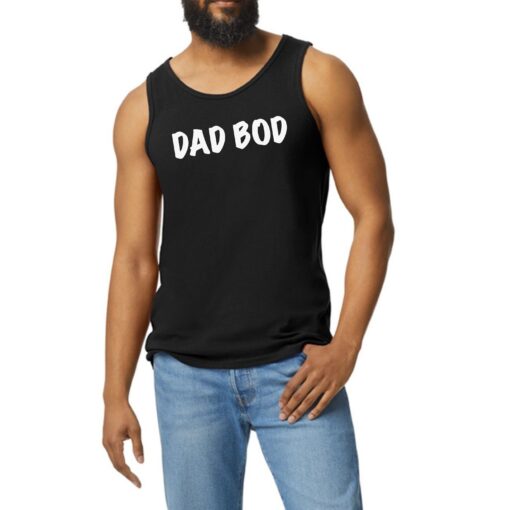 A man with a beard and jeans is wearing a black tank top.